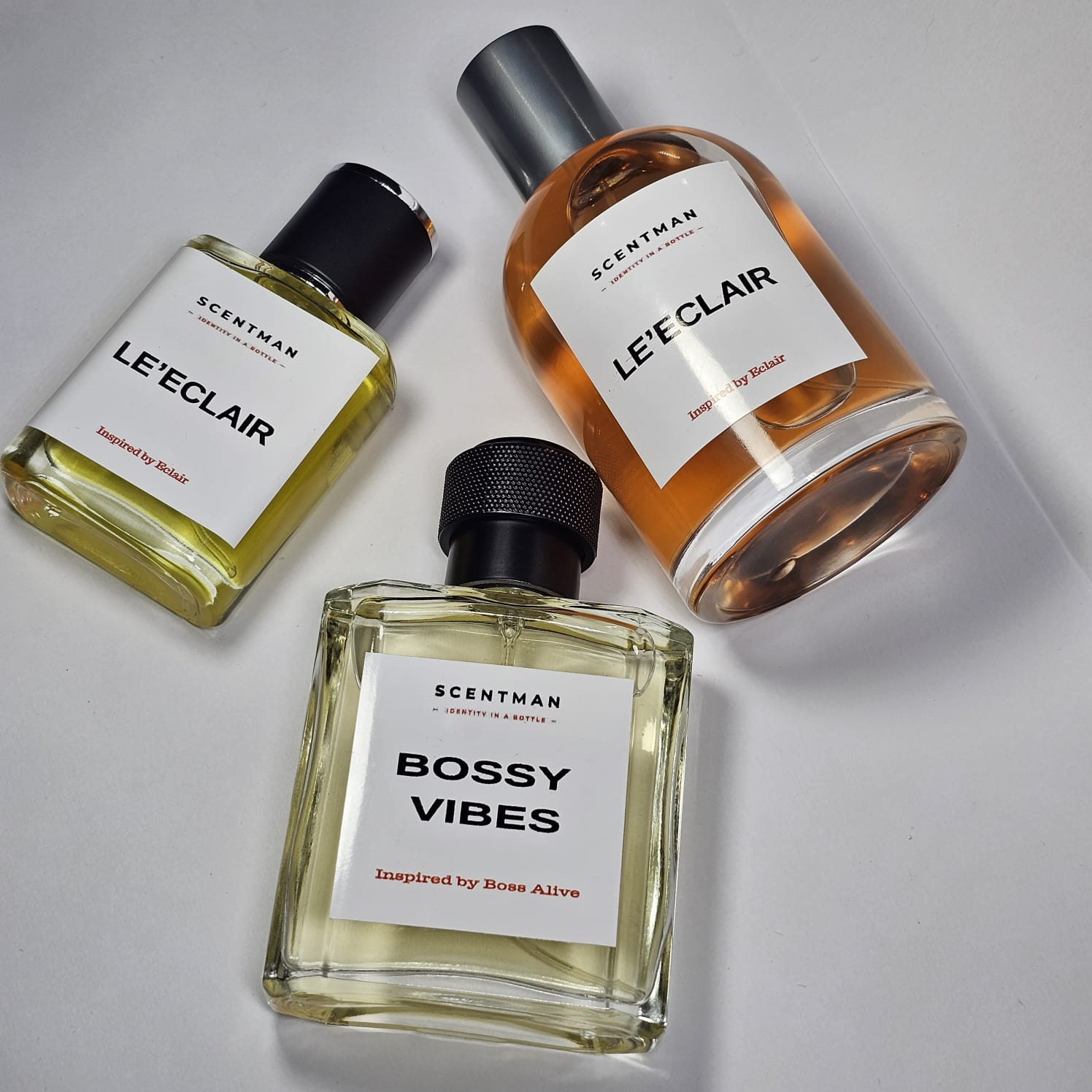 Three private labeled perfume bottled and branded under Scentman label. Brand name 'Leéclair' and 'Bossy Vibes' on a light grey background.